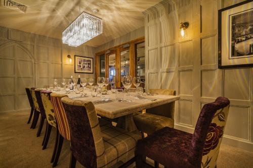 a dining room with a long table with wine glasses at The Swan Hotel, Stafford, Staffordshire - The Coaching Inn Group in Stafford