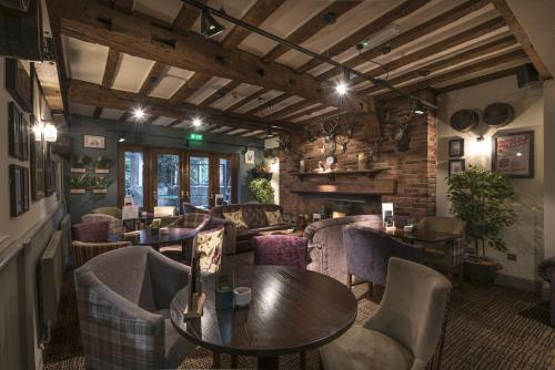a restaurant with tables and chairs in a room at The Swan Hotel, Stafford, Staffordshire - The Coaching Inn Group in Stafford