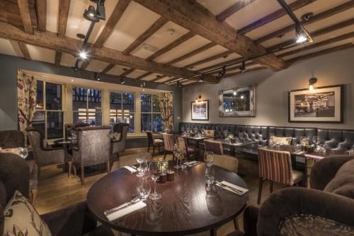 a restaurant with tables and chairs and a bar at The Swan Hotel, Stafford, Staffordshire - The Coaching Inn Group in Stafford