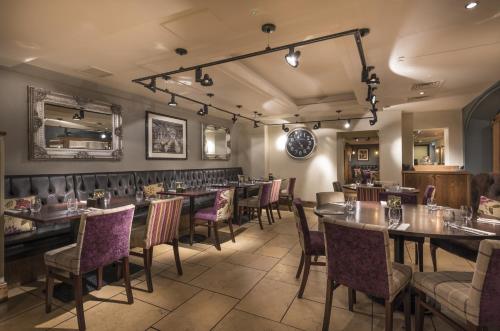 a restaurant with tables and chairs in a room at The Swan Hotel, Stafford, Staffordshire - The Coaching Inn Group in Stafford