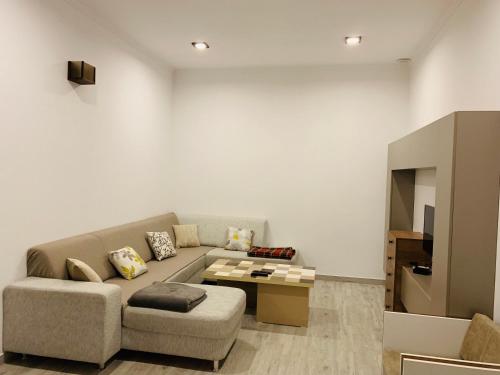 ein Wohnzimmer mit einem Sofa und einem TV in der Unterkunft Apartment Soho Tabidze in Kutaissi