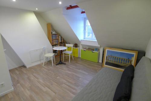 a attic room with a bed and a table and chairs at Altes Krupphaus auf der Heimaterde in Mülheim an der Ruhr