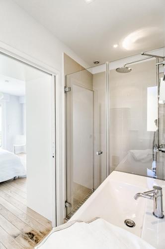 une salle de bain blanche avec un lavabo et un miroir dans l'établissement Luxurious Penthouse with panoramic view, à Villefranche-sur-Mer