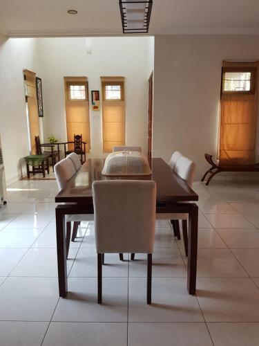 - une salle à manger avec une table et des chaises en bois dans l'établissement Pesona Air - Villa and Private Pool, à Depok