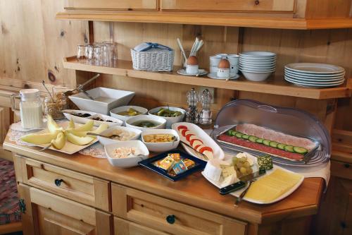 un buffet di cibi su un tavolo di legno di Haus Scheibler a Sankt Anton am Arlberg