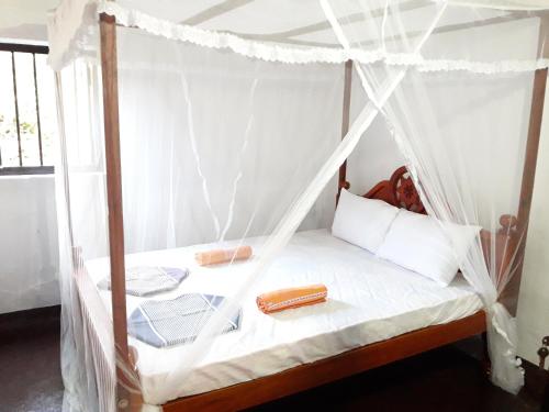 a bedroom with a bed with a canopy at Villa Pipe Dream in Tangalle