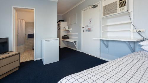 a small room with a bed and a television at Blue Mountains Highway Motel in Katoomba