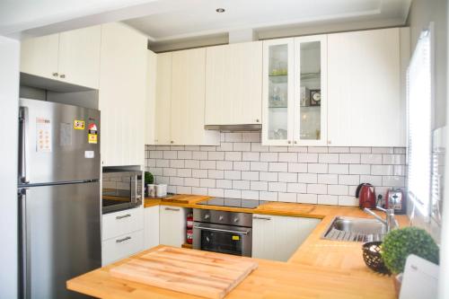 a kitchen with white cabinets and a stainless steel refrigerator at Gregory's Place Short Term Rental Western Sydney in Colyton