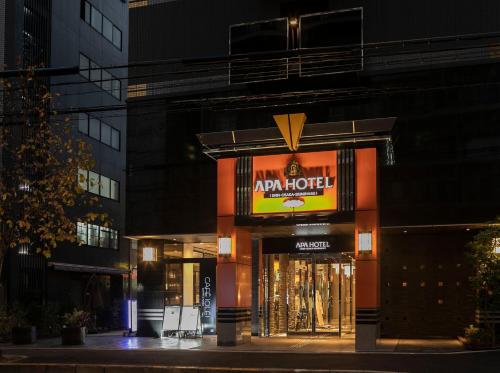 uma loja com uma placa na lateral de um edifício em APA Hotel Shin-Osaka-Ekiminami em Osaka