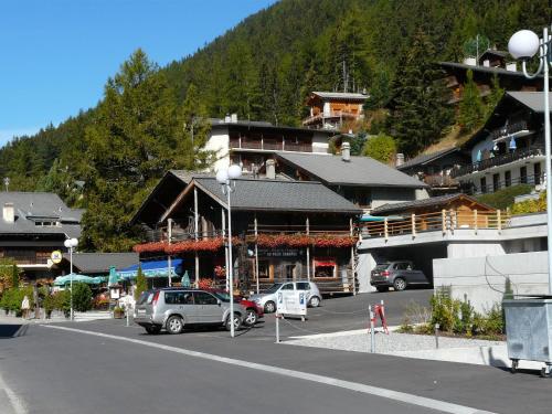 a street with cars parked in front of a building at Au Vieux Champex in Champex