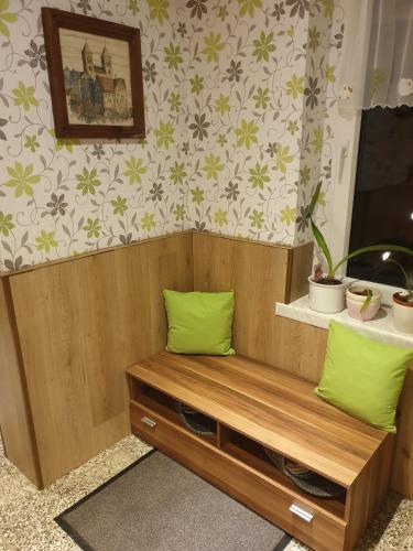 a wooden bench with green pillows in a room at Ferienwohnung Wendehake in Quedlinburg