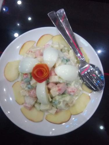 a plate of potato salad with a fork and spoon at Nayathali Hotel & Lodge Pvt. Ltd in Kawasoti