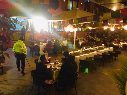 a group of people sitting at tables in a restaurant at Dalai-La Boutique Hotel in Kathmandu