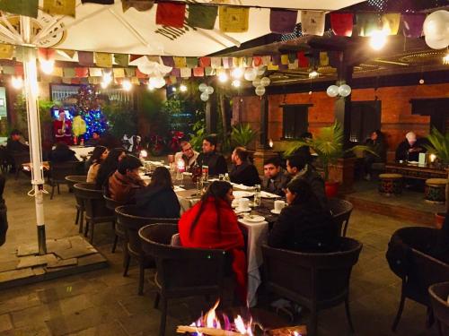 a group of people sitting at a table in a restaurant at Dalai-La Boutique Hotel in Kathmandu