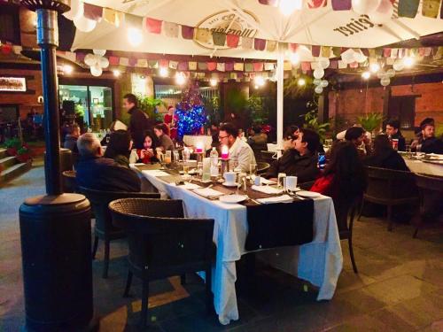 un grupo de personas sentadas en una mesa en un restaurante en Dalai-La Boutique Hotel, en Katmandú