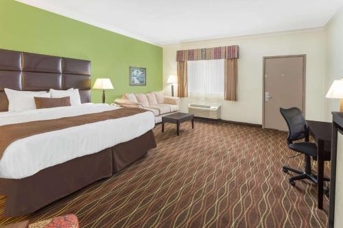 a hotel room with a large bed and a couch at Baymont by Wyndham Helen in Helen