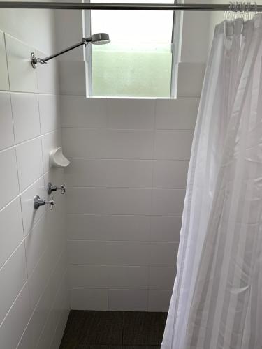 y baño con ducha y cortina de ducha. en Mariner Motel, en Laurieton