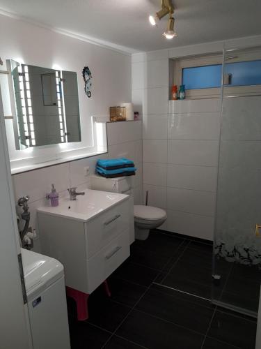 La salle de bains blanche est pourvue de toilettes et d'un lavabo. dans l'établissement Ferienwohnung Hoffmann Grossdeuben EG, à Böhlen