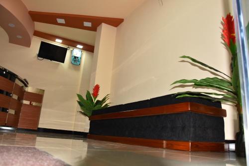 eine Lobby mit einem Sofa und einem TV an der Wand in der Unterkunft Hotel Lovusiyah in Jaffna