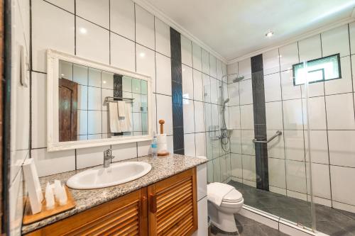 uma casa de banho com um lavatório, um chuveiro e um WC. em Bohol Sea Resort em Panglao City
