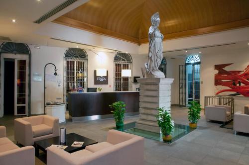 a lobby with a statue in the center of a building at Itaca Jerez by Soho Boutique in Jerez de la Frontera