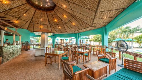 een restaurant met blauwe muren en houten tafels en stoelen bij Bohol Sea Resort in Panglao
