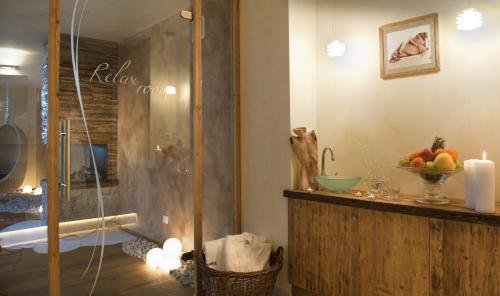 a bathroom with a shower and a bowl of fruit on a counter at Hotel Florian in Selva di Val Gardena
