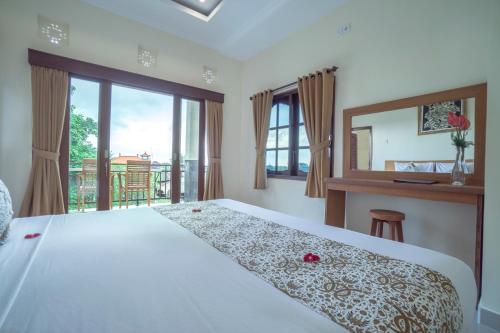 ein Schlafzimmer mit einem großen Bett und einem Balkon in der Unterkunft Japa House in Ubud