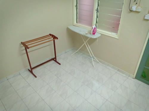 a white tiled room with a table and a window at Homestay Sejati in Kuala Berang