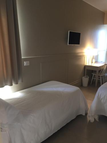 a bedroom with a bed and a desk with a television at La Chiave dei Trabocchi in San Vito Chietino