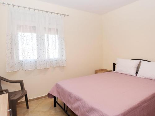 a bedroom with a bed and a chair and a window at Mama's Twin Houses in Áyios Mámas