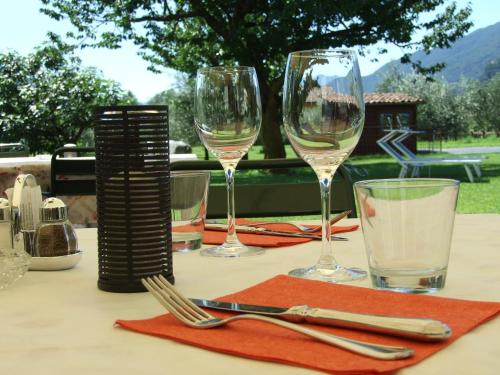 a table with glasses and utensils on a table at Agriturismo Cà Del Lago in Gravedona