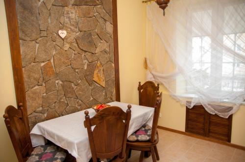 einen Tisch und Stühle in einem Zimmer mit einer Steinmauer in der Unterkunft Apartament Parkowy in Sandomierz