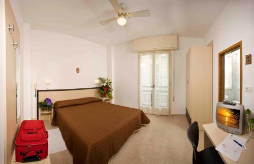 ein Schlafzimmer mit einem Bett und einem roten Koffer in der Unterkunft Amoha Hotel - Cattolica in Cattolica