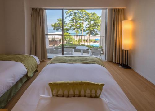 
a bedroom with a bed and a window at Izu Imaihama Tokyu Hotel in Kawazu
