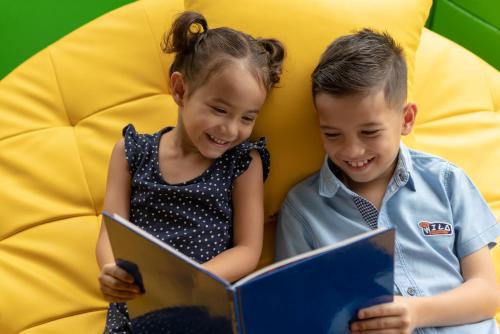 a boy and a girl reading a book at Pullman Luang Prabang in Luang Prabang