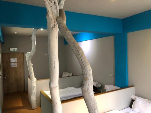 duas árvores num quarto com uma cama em A Good Man Hostel em Hualien