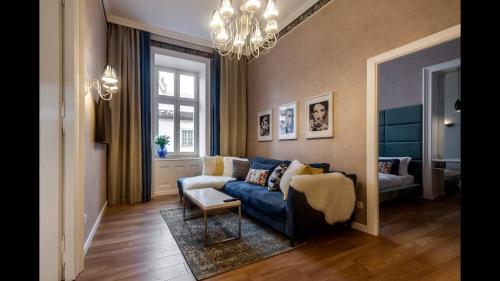 a living room with a blue couch and a chandelier at Lviv Apartments in Lviv