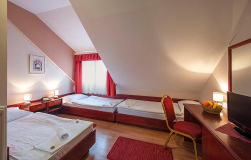 um quarto com 2 camas, uma secretária e uma televisão em B&B Garestin em Varaždin