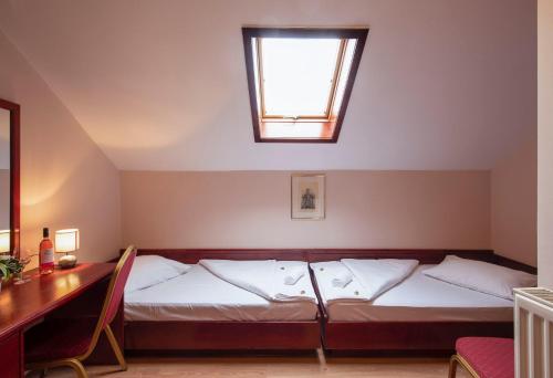 a bedroom with a bed with a window and a desk at B&B Garestin in Varaždin