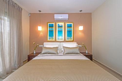 1 dormitorio con 1 cama y 2 ventanas en Villa4Dreams, en Gerani