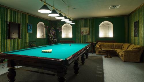 a pool table in a room with green walls at Kremlyovsky Hotel in Suzdal
