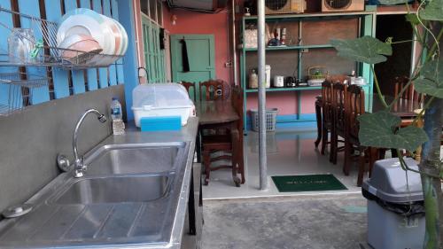 a kitchen with a sink and a table and chairs at Sun smile(cafe & homestay) in Ubon Ratchathani