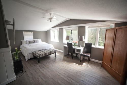 1 dormitorio con 1 cama, mesa y sillas en Tall Trees Bed & Breakfast, en Prince Rupert