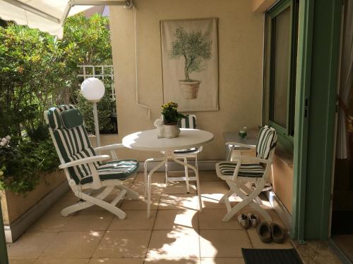 un patio avec une table et des chaises sur un porche dans l'établissement Studio cosy à Villefranche sur mer, à Villefranche-sur-Mer