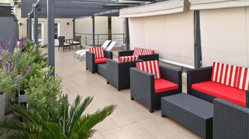 a row of chairs with red cushions on a patio at San Telmo Suites in Buenos Aires