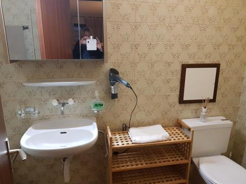een vrouw die een foto neemt van een badkamer met een wastafel bij Appt 6-8 pers Torgon Portes du Soleil in Vionnaz