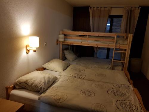 a bedroom with two bunk beds and a lamp at Appt 6-8 pers Torgon Portes du Soleil in Vionnaz