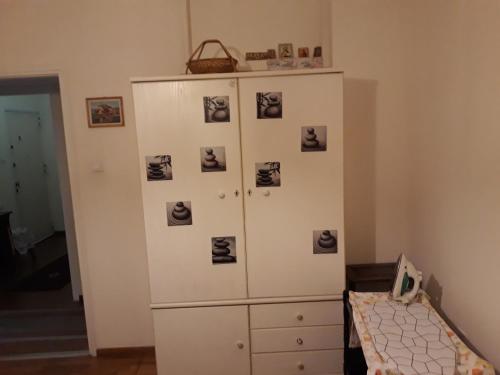 a white cabinet with pictures on it in a room at Apartment on Dimitrakopoulou in Athens