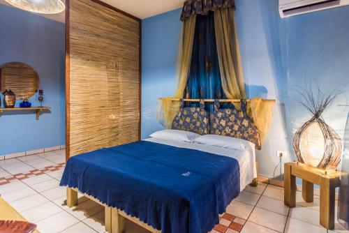 een slaapkamer met blauwe muren en een bed met blauwe lakens bij B&B Cinque Stelle Salento in Marina di Mancaversa